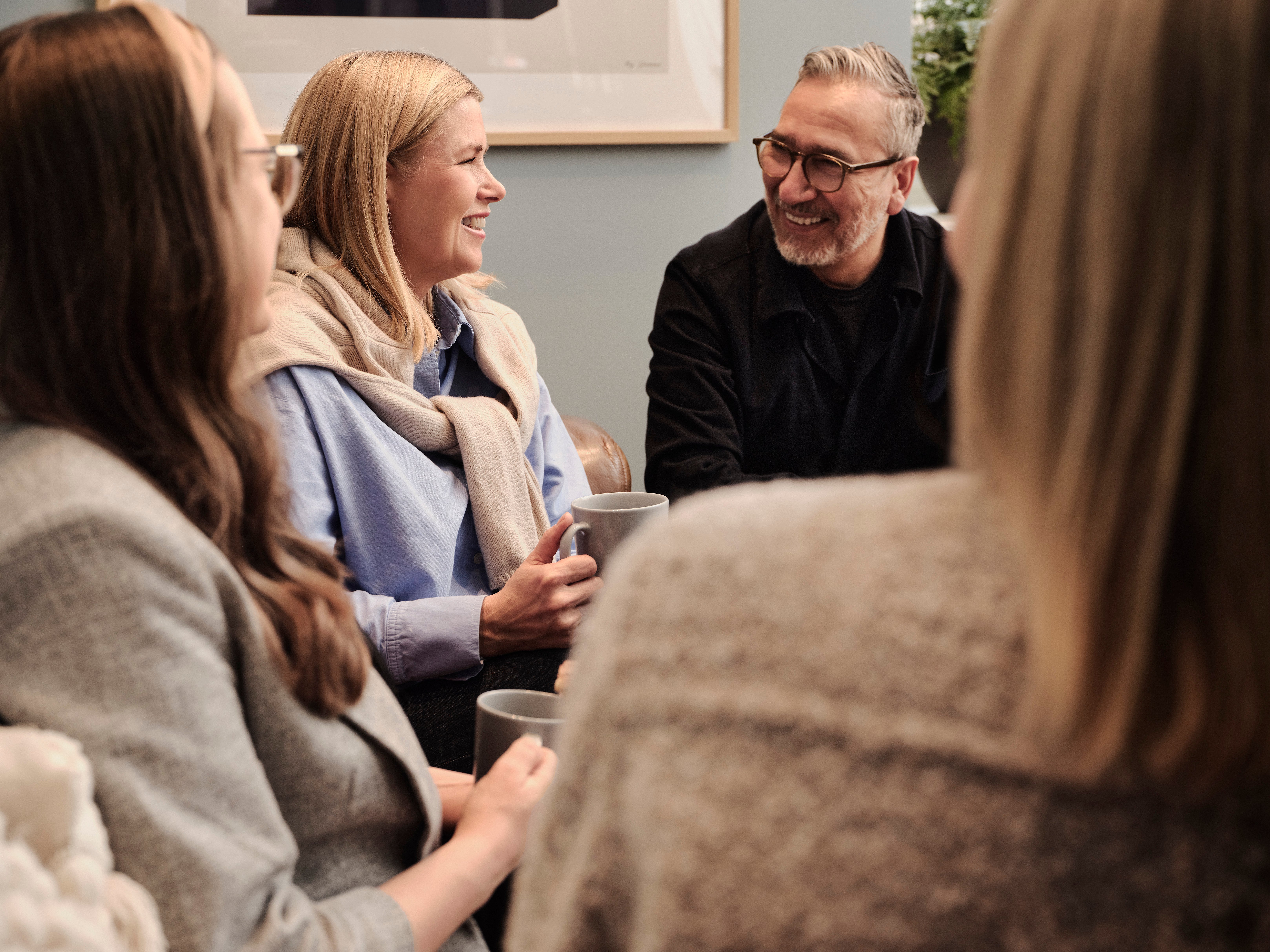 En grupp människor som sitter runt ett bord och pratar.